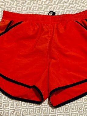Women’s orange Under Armour Athletic Shorts with Black Trim